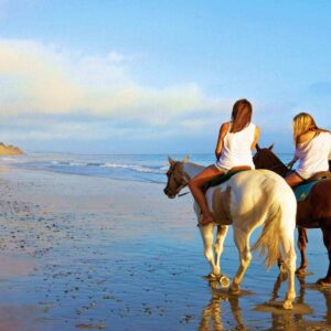 Three girls riding horses on Tamarindo beach