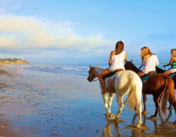 Three girls riding horses on Tamarindo beach