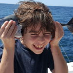 Child having fun with a fish in private boat discovery combo